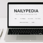 Laptop showing Nailypedia – online nail knowledge hub with guides on BIAB, nail allergies, greenie nails, patch testing, and client consent forms, surrounded by nail tools and polish bottle